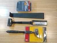 Full overview of laminate and wood flooring tools and accessories arranged on wood surface.