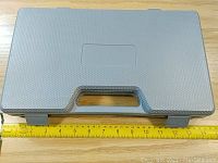 Closed textured gray plastic carrying case measuring approximately 35cm wide