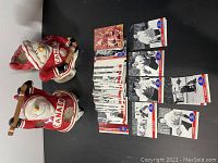 Two Team Canada snowman ceramic candle holders and a spread of Team Canada hockey cards on black background.