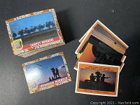 Photo of two Desert Storm trading cards: Carpet Bombing and Stinger Missile with a small pile of cards and a puzzle completition card visible.