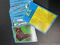 Front and back view of some cards showing E.T. character images and text description on back with checklist.
