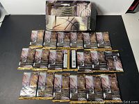 Opened display box at top, 19 foil-wrapped packs arranged below on black surface