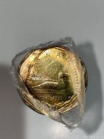 Rolled stack of 25 Canada Regular Loon coins sealed in original shrink-wrap showing the top coin with the loon design, year range 1867-1992.