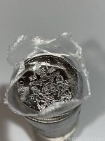 Close-up photo of the top of the roll revealing the 1999 Canadian 50 cent coin with the Canadian coat of arms design, sealed in clear plastic.