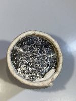 Close-up photo showing the top end of the coin roll with a visible 1993 Canada half dollar coin featuring the Canadian coat of arms.