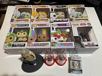 Photo showing all boxed Funko Pop figures and additional collectibles on white surface, arranged for viewing