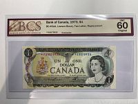 Front of the 1973 Canadian $1 replacement note with serial number and grading label.