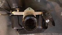 Front view of vintage Honeywell Pentax camera showing lens, brand markings, and leather case