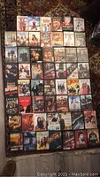 Photo showing a variety of 55 DVD movies laid out, including kids movies and action-adventure films.