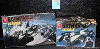 Two Batman model kits side by side showing box fronts and condition: Batwing box is creased with some wear, Batmobile box heavily damaged top right corner and edge.