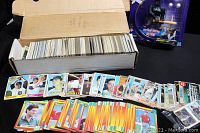 Box of 785 baseball cards with cards spread out showing various baseball player cards from different teams and years.