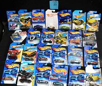 Overview of 25 assorted Hot Wheels cars, all in original blister card packaging.