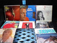 Photo showing vinyl albums including Tony Carroll, Woody Woodbury, Birgit Nilsson, and others, highlighting a variety of cover art styles and pre-owned condition.