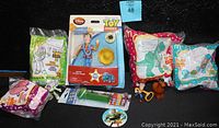 View of Toy Story collectibles including Jessie figure in packaging, McDonald's Happy Meal toys in original packaging showing Rex and Mr. Potato Head, and small loose figures Woody and Bullseye.