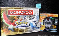 Boxed Monopoly Pokemon Edition board game featuring Ho-Oh and Lugia on cover with visible game box.