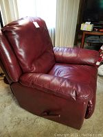 Side view of the medium red leather rocker recliner chair showing the armrest, side lever for reclining, and overall shape.