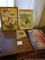 Two vintage framed oil paintings, one 3D painted small glass picture, and two unopened frames on table