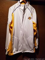 Front of white Lakers jacket showing full zip, Reebok collar logo, Lakers patch on chest