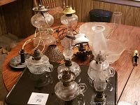 Full lot overview showing all lamps, shades, and candle holders arranged on a wooden table