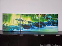 Front view of the 3-piece Stream & Stones photographic wall art aligned horizontally on a shelf.