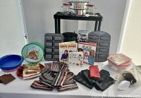Overview of multiple bakeware items, some kitchen linens, cookbooks, and glass flutes on white table