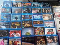 Top view displaying a variety of Blu-ray and DVD movie cases including Avatar, John Wick, Oceans, Batman, Resident Evil Afterlife, and others.