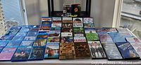 Photo highlighting a wider view of the lot showing many Blu Ray and DVD movies. Includes Jurassic Park Adventure, Fargo, Brides Maids, Dear John, The Mummy, The Sixth Sense, and others.