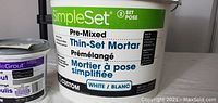 Photo showing white bucket of SimpleSet Pre-Mixed Thin-Set Mortar with labeling visible