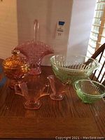 Photo showing entire set of vintage colored glassware on wooden table, highlighting different colors and shapes
