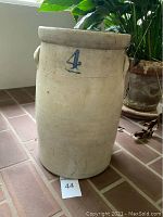 Full view of the vintage stoneware crock showing front with blue '4' stamp and handle.