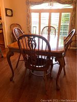 Front view of rectangular oak dining table at full length with four chairs