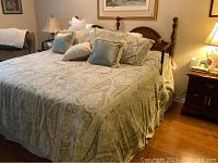 Full view of assembled king bed with bedding and pillows in bedroom setting