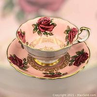 Paragon cup with pink rose pattern and gold gilt accent on display with matching saucer.