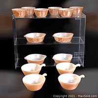 14 pieces of vintage FIRE-KING Copper Tint ovenware including 6 scalloped rim custard bowls, 4 round swirl casserole bowls, 4 ribbed French casseroles with handles. Display stand not included.