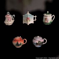 Five vintage mustard/jam jars with intricate handles and lids featuring floral, scenic, and young girl motifs