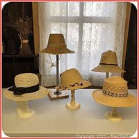 All five vintage ladies straw hats shown on white stands, variety of styles and decorations.