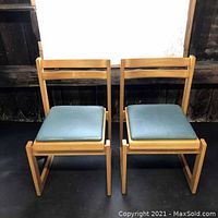 Front view of the pair of Mid-Century Modern side chairs showing wooden frames and blue upholstered seats.