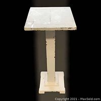 Front view of vintage wooden plant stand showing square top and base with paint chipping.