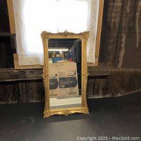 Front view of vintage gold framed mirror showing ornate detailing and overall condition