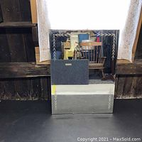 Front view of vintage mirror showing etched leaf/vine design in corners and good reflective surface.