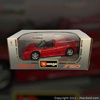 Front view of the BBURAGO Ferrari F50 model car in original silver box with clear display window showing the red model car.