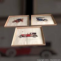 Three framed vintage car prints displayed together on a wall: Cadillac Model A 1902, Buick Model C 1905, Cadillac V-16 Fleetwood Town Brougham 1931.