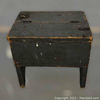 Front angled view of vintage wooden shoe shine box with visible wear to paint and edges.