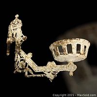 Photo of Victorian swing arm metal wall sconce from side showing detailed design and paint chipping.