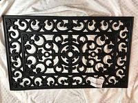 Single black rubber doormat showing full scroll cutout pattern and rectangular shape.