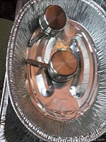 Top view of one chafing dish showing two metal Sterno fuel holders in aluminum pan.