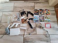 Photo showing Nintendo Wii console, multiple controllers, sensor bar, power and AV cables.