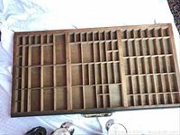 Top view of the wooden print set drawer showing multiple compartments of various sizes.