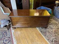 Closed view of the Lane mahogany cedar chest showing polished wood surface and decorative carved feet.