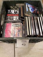 Box filled with various CD jewel cases including Chicago musical and Clueless movie soundtrack visible on top.